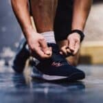 Close up of a male's hands tying shoelace in a gym. Sportsman preparing for a training